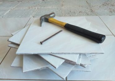 a hammer sitting on top of a pile of tile